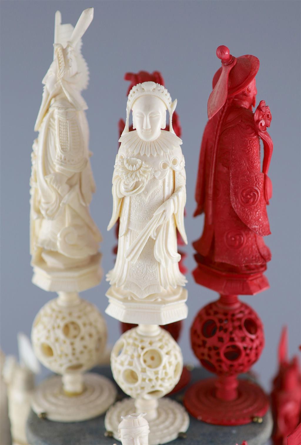 A set of 19th century Cantonese carved and red stained ivory chess pieces under dome, white king 20cm high